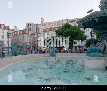 Fontaine et Mermaids sur la place Rossio une soirée d'été à Lisbonne avec l'église Carmo et les ruines du couvent en arrière-plan. Portugal Banque D'Images