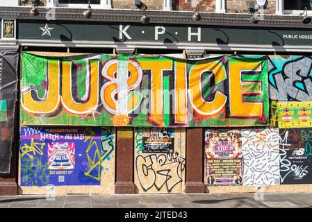 Bannière de soutien Grenfell au Notting Hill Carnival, le lundi 2022 août des fêtes de banque à Londres, Royaume-Uni. Message de justice et graffiti à l'extérieur du pub fermé Banque D'Images