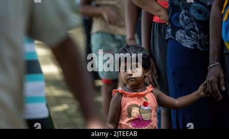 Enfant en attente de recevoir un colis alimentaire d'une communauté almsdonning: Galle, Sri Lanka 30th juillet 2022 Banque D'Images