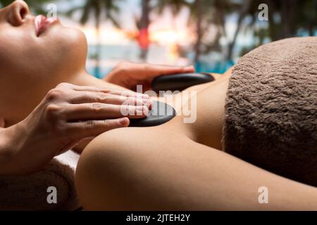 gros plan d'une femme ayant un massage aux pierres chaudes au spa Banque D'Images