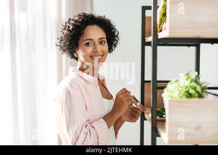 femme avec allumettes éclairant des bougies à la maison Banque D'Images