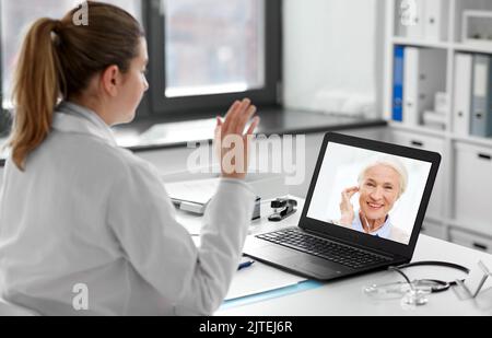 médecin avec ordinateur portable ayant un appel vidéo avec le patient Banque D'Images