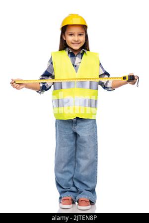 petite fille en casque de construction avec règle Banque D'Images