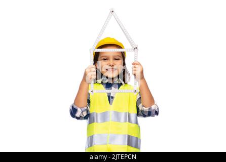 petite fille en casque avec règle en forme de maison Banque D'Images