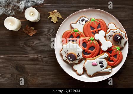 Biscuits au pain d'épice d'Halloween - citrouilles, fantômes, araignée et os sur fond de bois. Vue de dessus. Place pour une inscription. Banque D'Images