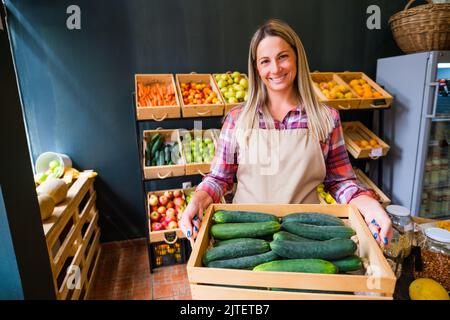 Portrait du propriétaire du supermarché Happy Food. Femme travaille dans la boutique de fruits et légumes. Banque D'Images