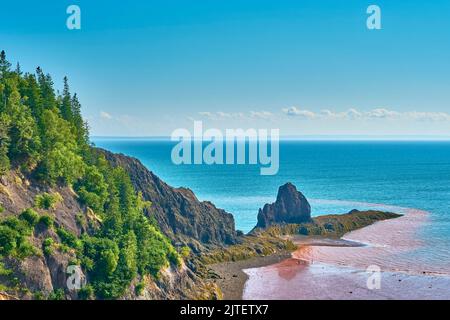 Les gens explorant le fond de l'océan sous des falaises de 90 mètres et de 300 pieds alors que la marée se retire dans la baie de Fundy, à Five Islands Nova Scotia. Banque D'Images