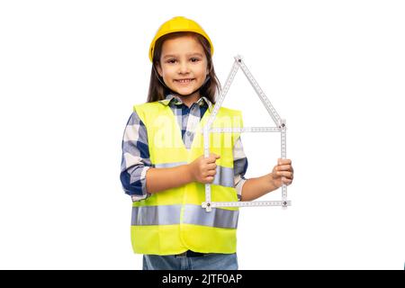 petite fille en casque avec règle en forme de maison Banque D'Images