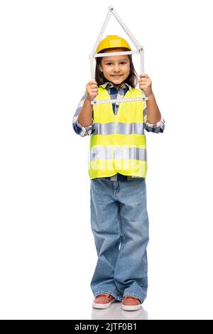 petite fille en casque avec règle en forme de maison Banque D'Images