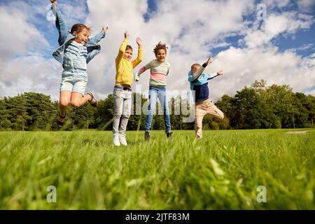 des enfants heureux sautant au parc Banque D'Images