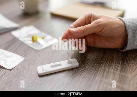 femme effectuant un test d'auto-dépistage du coronavirus à la maison Banque D'Images