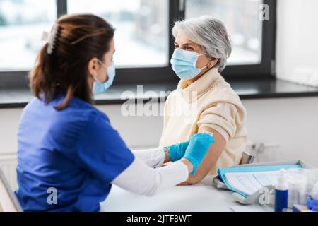 médecin préparant la femme âgée à la vaccination Banque D'Images