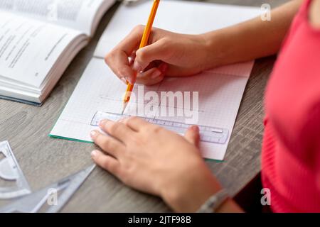 étudiant avec une règle et un crayon dans un bloc-notes Banque D'Images