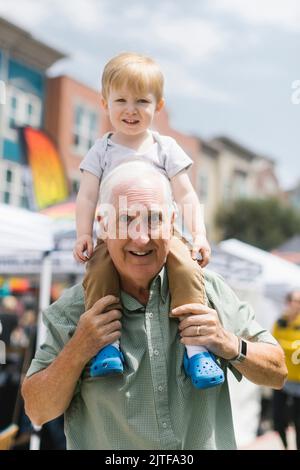 Portrait du grand-père portant le petit-fils (2-3) sur les épaules Banque D'Images