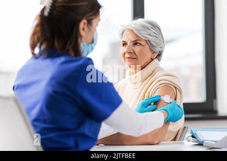 infirmière appliquant le patch médical à la femme vaccinée Banque D'Images