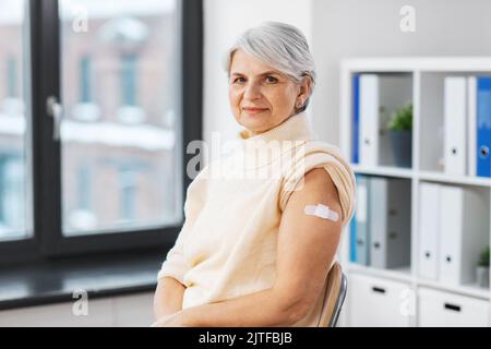 femme vaccinée avec un patch médical sur le bras Banque D'Images