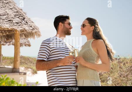 couple heureux de boire du champagne sur la plage d'été Banque D'Images