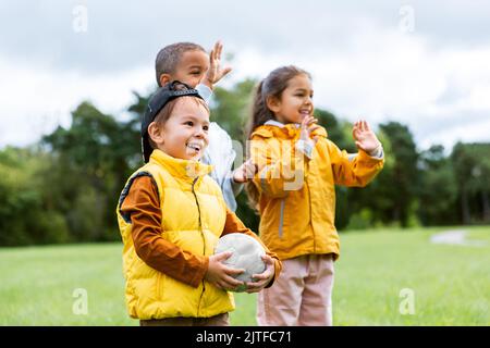 des enfants heureux avec un ballon de football au parc Banque D'Images