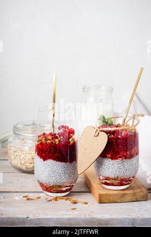 Deux verres de gâteau au chia avec granola et framboises. Banque D'Images