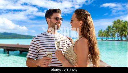 couple heureux de boire du champagne sur la plage d'été Banque D'Images