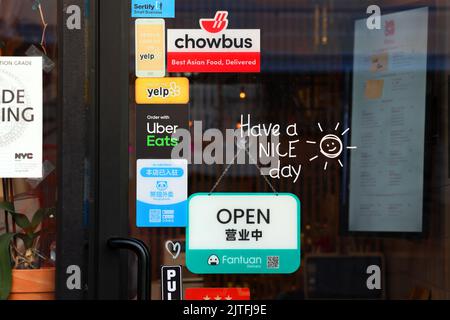 Chowbus, Fantuan Delivery, Hungry Panda, Uber Eats food service de livraison des autocollants d'application sur une porte d'un restaurant asiatique à New York. Banque D'Images