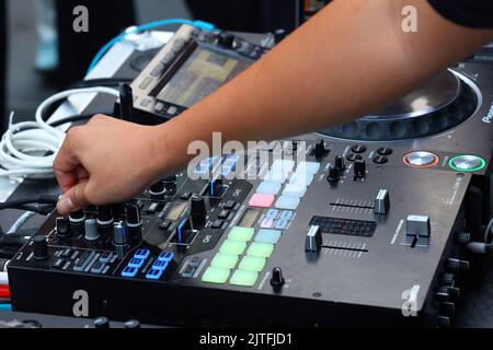 Un DJ de fête tourne un bouton sur un plateau de mixage numérique Pioneer DJM-S9 pour régler les notes « Hi » sur une piste de musique lors d'une fête de danse Banque D'Images