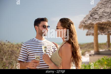 couple heureux de boire du champagne sur la plage d'été Banque D'Images