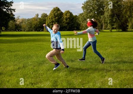 enfants heureux jouant et courant au parc Banque D'Images