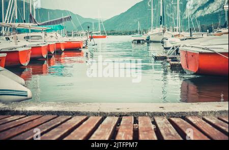 Jetée en bois pour amarrer des bateaux sur le lac de montagne en belle journée ensoleillée, Autriche. Paysage d'été idyllique des Alpes. Ton rétro vintage Banque D'Images