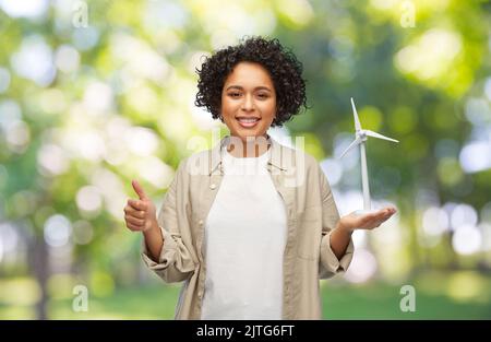 femme tenant l'éolienne jouet montrant les pouces vers le haut Banque D'Images