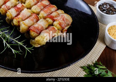Brochettes de manioc enveloppées de bacon, médaillon de manioc. Banque D'Images