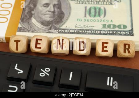 Concept d'entreprise. À côté de la calculatrice et des dollars sont des cubes avec l'inscription - TENDRE Banque D'Images