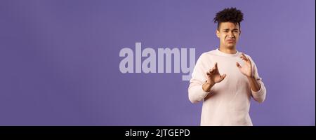 Phew l'éloigner de moi. Portrait de jeune homme déguisé qui a frappé quelque chose d'horrible, s'éloigner et le bloquer avec les bras levés, refuser de grimaquer avec Banque D'Images