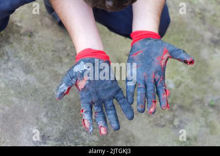 Flou artistique gants sales et étanches. Ouvrir les mains dans des gants de travail usés, protection contre les dommages pendant le fonctionnement, gros plan sur le dos de la nature Banque D'Images