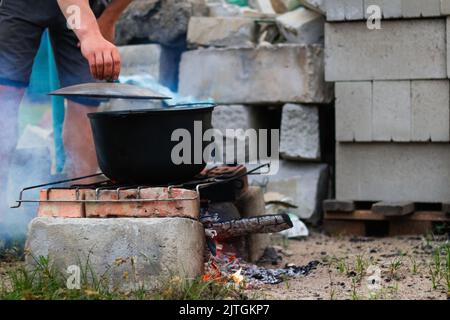 Recentrer la soupe de poisson dans le melon de fer sur un feu de camp. La soupe de poisson bout dans le chou-fleur. Soupe dans un pot dans le feu. Camp de jour. Vert nature gr Banque D'Images