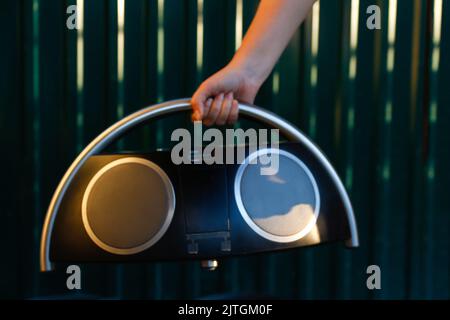 Flou artistique main tenant l'enregistreur de musique rétro. Ampli-tuner radio stéréo portable de type boombox rétro avec lecteur/enregistreur de cassettes. PH filtré ancien style vintage Banque D'Images