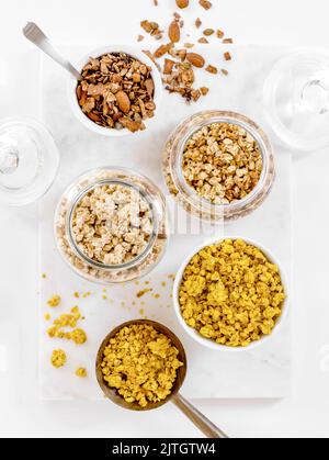 Divers types de granola de petit déjeuner en pots et cuillères de service Banque D'Images