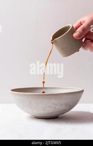 Versez à la main la verseuse de café dans un bol en céramique. Banque D'Images
