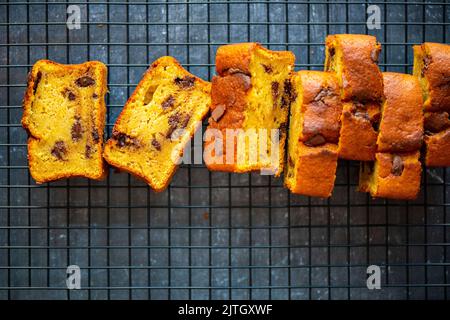 Pain de citrouille aux pépites de chocolat tranché sur une grille de refroidissement sur fond sombre. Banque D'Images