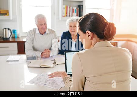 Aider à faire leur argent travailler pour eux. Un couple senior obtenant des conseils de leur conseiller financier. Banque D'Images