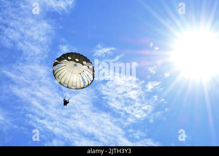 Rhode Island, États-Unis. 6th août 2022. Le cavalier descend au soleil vers la zone de dépôt de Glen Rock pendant le Leapfest 2022 à Exeter, Rhode Island, Auguste 6, 2022. Leapfest est le plus grand événement international d'entraînement et de compétition de parachutisme en ligne statique organisé par le Commandement de la troupe de 56th de la Garde nationale de l'Armée du Rhode Island pour promouvoir l'entraînement technique de haut niveau et l'esprit de corps au sein de la communauté aéroportée internationale. Crédit: Armée américaine/ZUMA Press Wire Service/ZUMAPRESS.com/Alamy Live News Banque D'Images