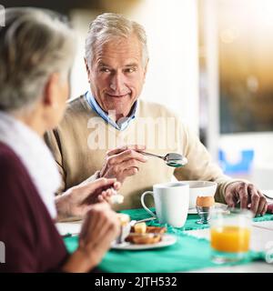 C'était notre propre club de petit déjeuner. Un couple de personnes âgées heureux qui appréciait le petit déjeuner ensemble à la maison. Banque D'Images