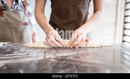 Le processus de fabrication de baguettes traditionnelles françaises. Former un blanc à partir de la pâte. Vue avant. Banque D'Images