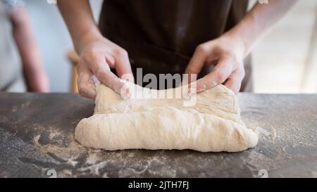 Le processus de fabrication de baguettes traditionnelles françaises. Former un blanc à partir de la pâte. Vue avant. Banque D'Images