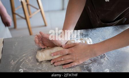 Le processus de fabrication de baguettes traditionnelles françaises. Former un blanc à partir de la pâte. Vue avant. Banque D'Images