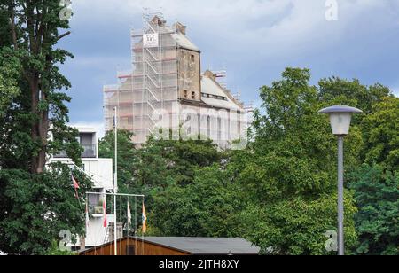 Oranienburg, Allemagne. 29th août 2022. L'ancien grenier d'Oranienburg peut être vu derrière des arbres près de la Louise-Henriette-Steg. L'échafaudage est d'environ 35 mètres de haut et se trouve sur la liste des monuments de l'état de Brandebourg. Après la destruction du premier grenier par un incendie majeur en 1916, le nouveau bâtiment a été érigé un an plus tard, l'un des premiers bâtiments en béton armé dans la région. Crédit : Soeren Stache/dpa/Alay Live News Banque D'Images