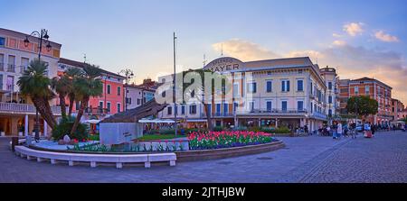 DESENZANO DEL GARDA, ITALIE - 10 AVRIL 2022: La soirée Piazza Giacomo Matteotti avec monument à Brave Aviators, entouré de massifs de fleurs de tulipe, Banque D'Images