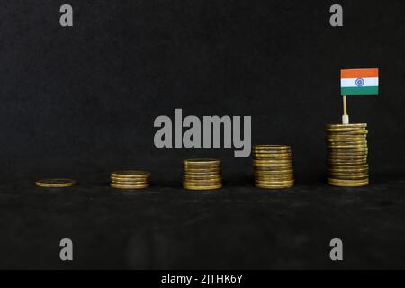 Inde croissance économique, reprise après crise financière et appréciation du peso. Drapeau indien dans la pile croissante de pièces en noir foncé Banque D'Images