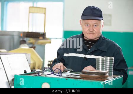 Tourner la production un homme âgé travaille à un tour. Travaux de tournage. Banque D'Images