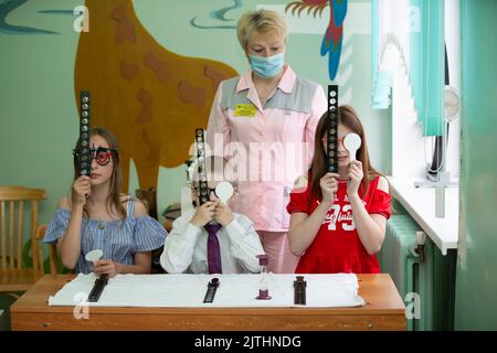 Biélorussie, ville de Gomil, 31 mai 2021. Centre de santé pour enfants. Un médecin équipé d'un équipement spécial pour les yeux corrige les problèmes de vision chez les enfants. Banque D'Images